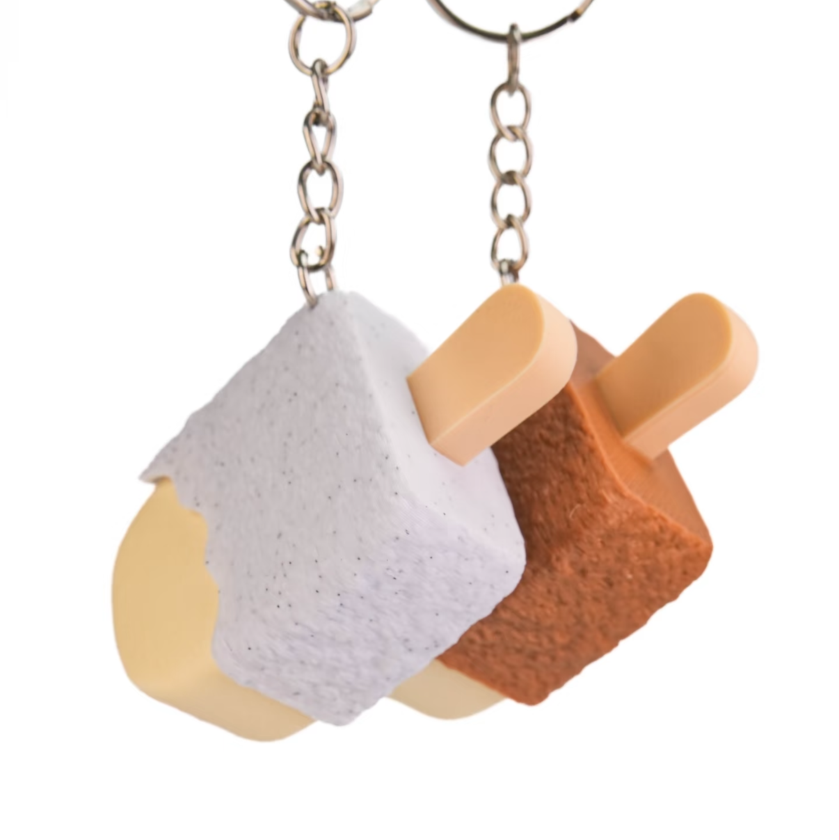 Two novelty keychains shaped like mini ice cream cones, one with a white textured top and one with a brown textured top, hanging from silver metal chains on a white background.
