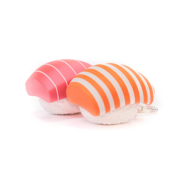 Two sushi-themed keychains shaped like nigiri, one pink with white stripes and one orange and white striped, displayed on a plain white background.