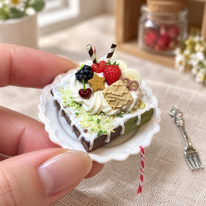 Miniature berry cake clay craft held between fingertips for scale